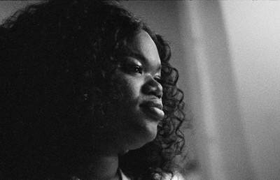 a black and white photo of a woman with curly hair