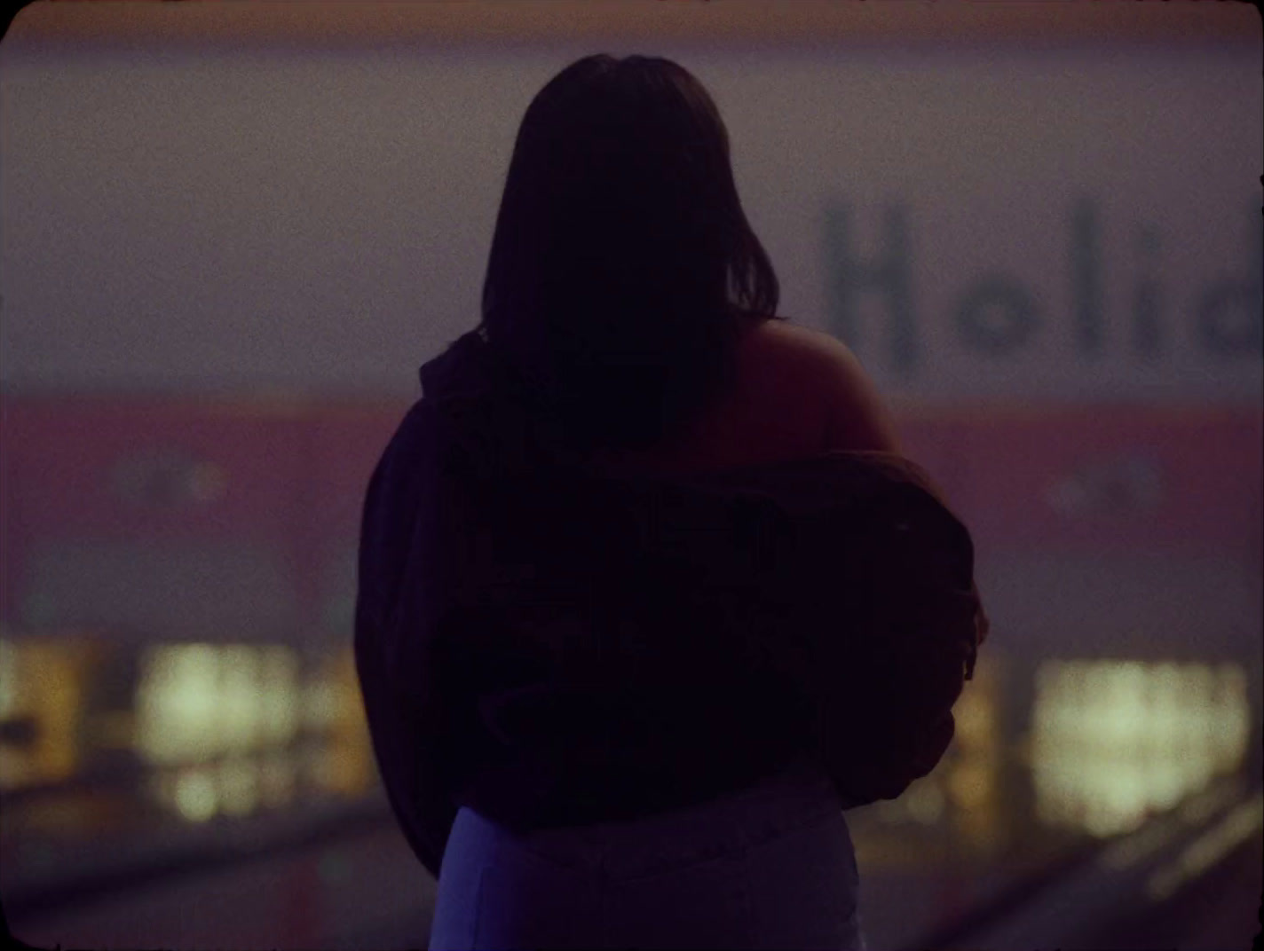 a woman standing in front of a building with her back to the camera