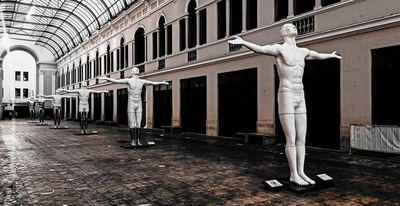 a group of statues in a building with a glass ceiling