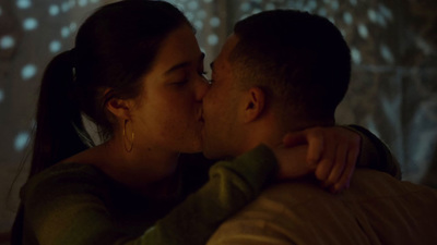 a man and a woman kissing in a dimly lit room