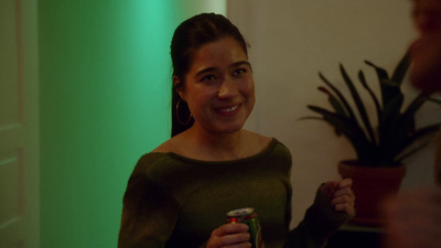 a woman standing in a room holding a can of soda