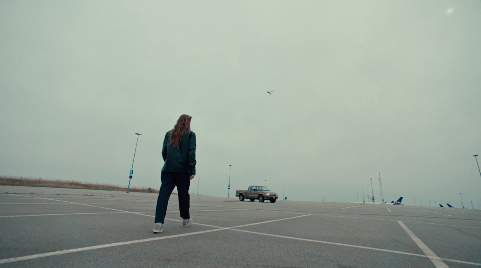 a woman standing in the middle of a parking lot