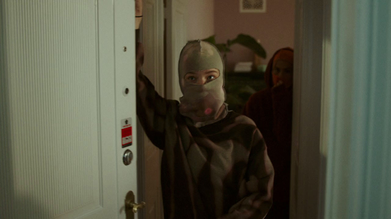 a person wearing a mask standing in front of a door