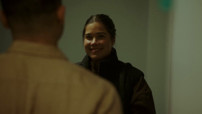 a woman smiles as she looks into a mirror