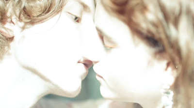 a close up of two people kissing each other