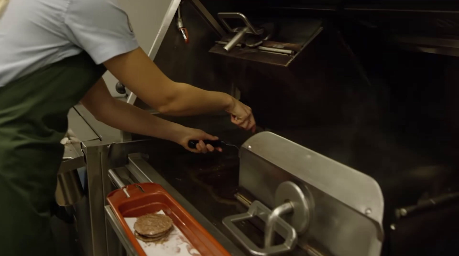 a woman in an apron is cooking food in an oven