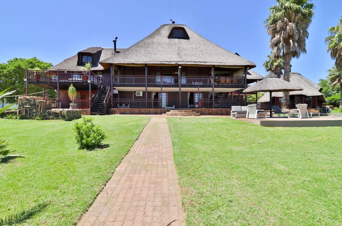 a large house with a thatched roof and a walkway leading to it