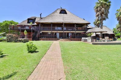 a large house with a thatched roof and a walkway leading to it