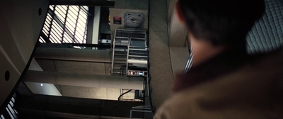 a man standing in front of a window next to a stair case