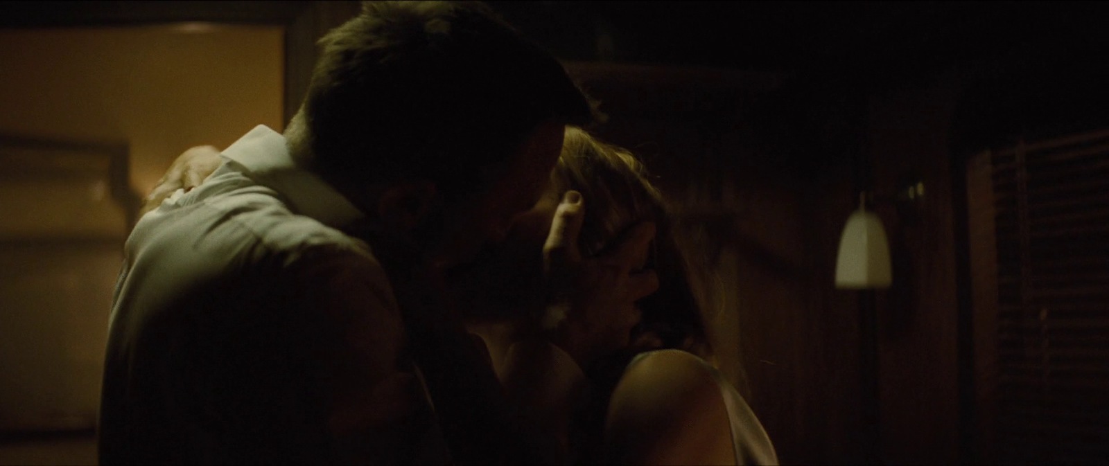 a man and a woman kissing in a dark room