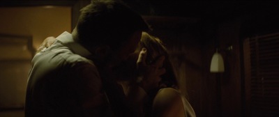 a man and a woman kissing in a dark room