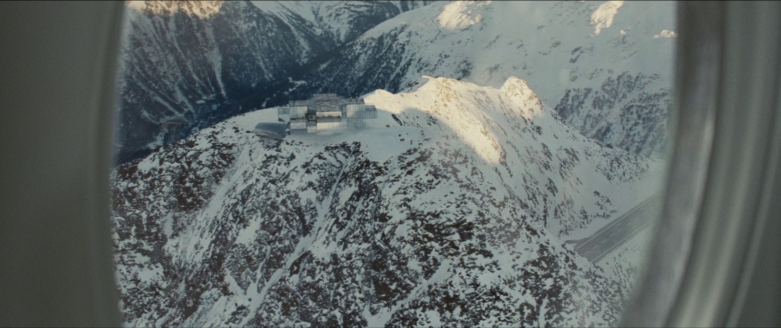 a view of a snowy mountain from an airplane window