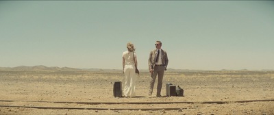 a man and a woman standing in the desert