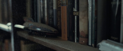 a bookshelf filled with lots of books next to a window