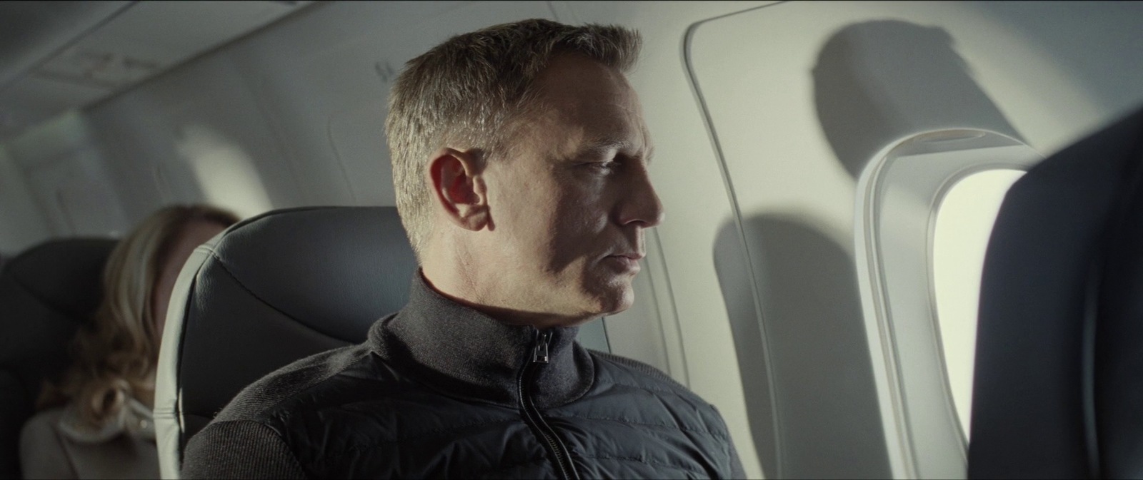 a man sitting in an airplane looking out the window