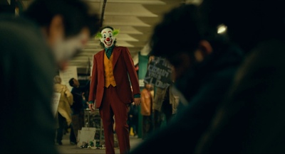 a man in a clown mask walking down a hallway