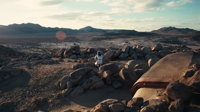 a person sitting on a rock in the middle of a desert