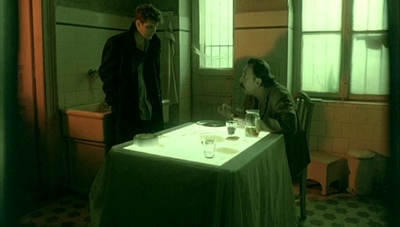 a man standing next to a woman sitting at a table