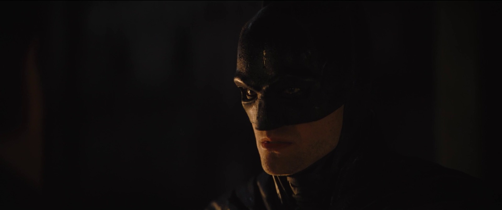 a man wearing a batman mask in the dark