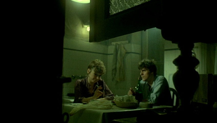 two people sitting at a table in a dark room