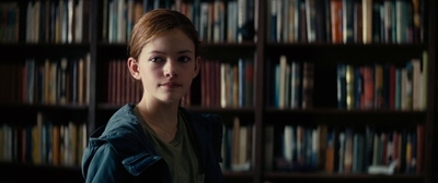 a woman standing in front of a bookshelf