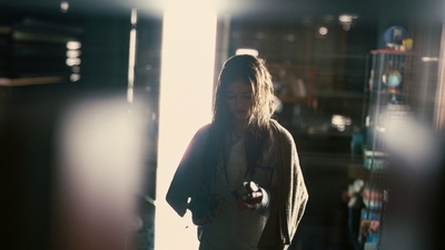 a woman standing in a room looking at her cell phone