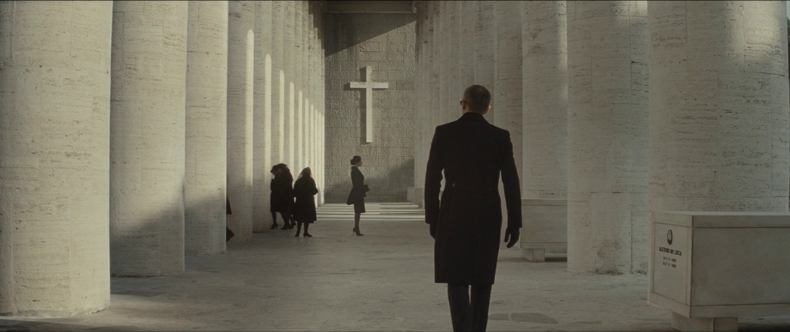 a man in a suit walking down a hallway