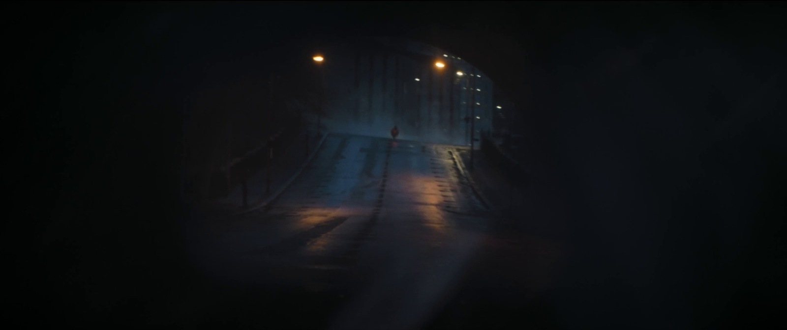 a person walking down a street at night