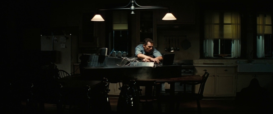 a man sitting at a table in a dark room