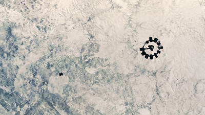 a group of people sitting on top of a snow covered ground