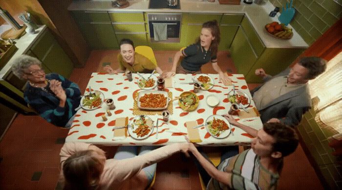 a group of people sitting around a table eating pizza