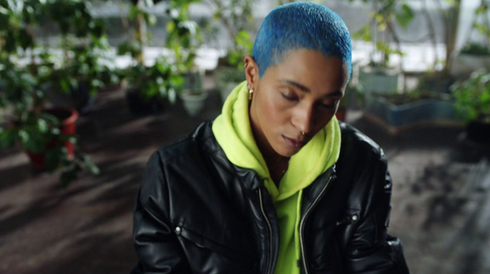 a woman with blue hair wearing a black jacket