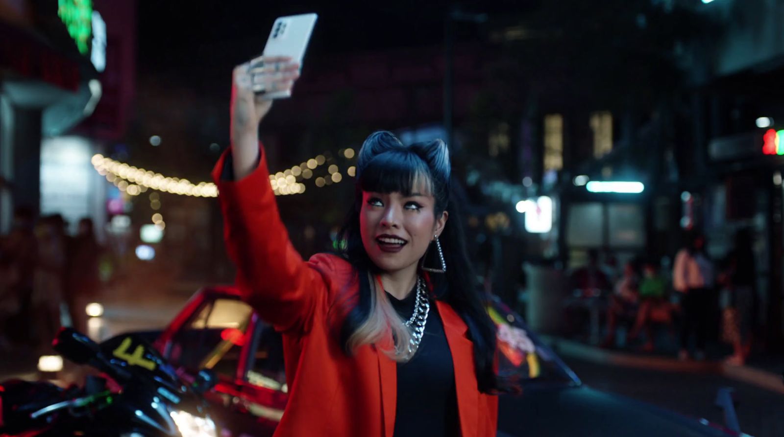 a woman holding a cell phone up in the air