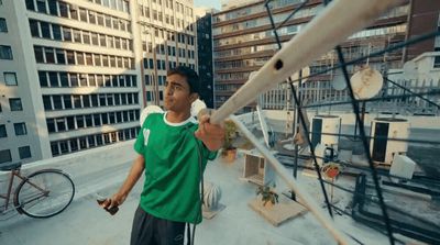 a man holding a baseball bat on top of a roof