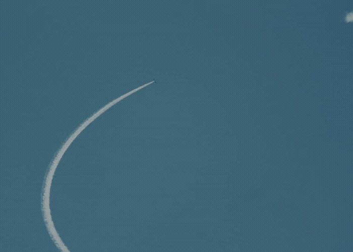 an airplane flying in the sky leaving a contrail