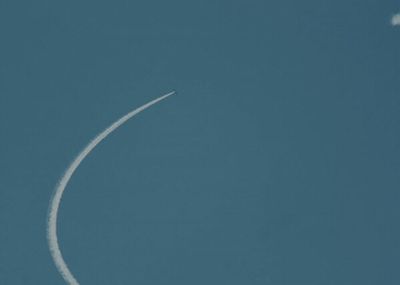 an airplane flying in the sky leaving a contrail