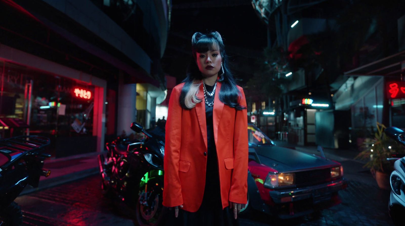 a woman standing in front of a parked car