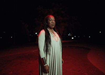 a woman in a white dress standing in the dark