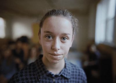 a woman with blue eyes is looking at the camera