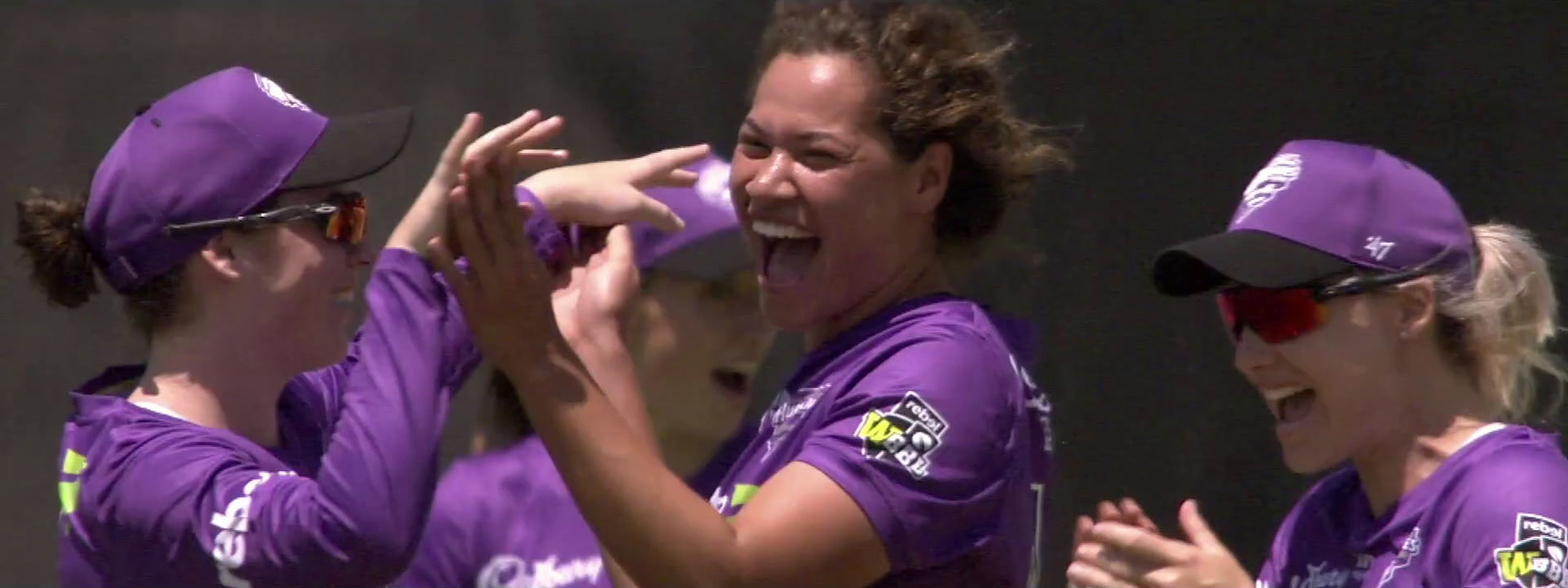 a group of women in purple shirts standing next to each other