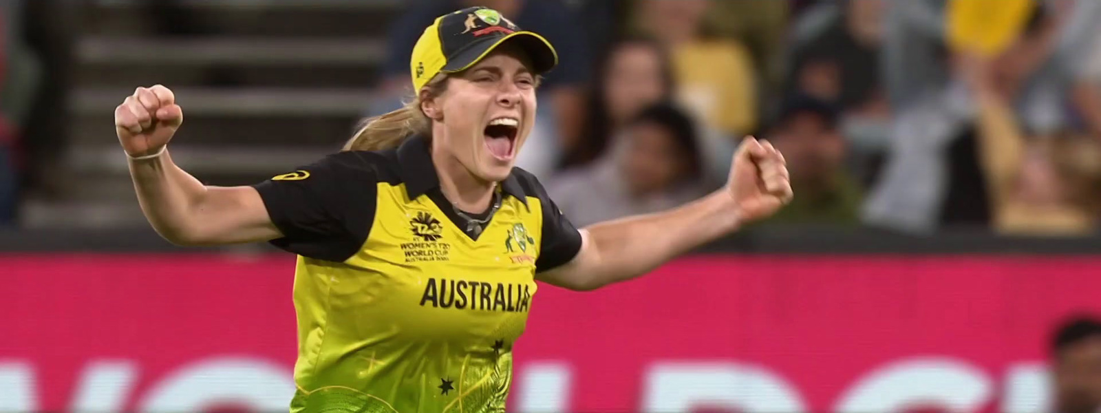 a woman in a yellow and black uniform celebrating