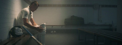 a man in white shirt holding a baseball bat