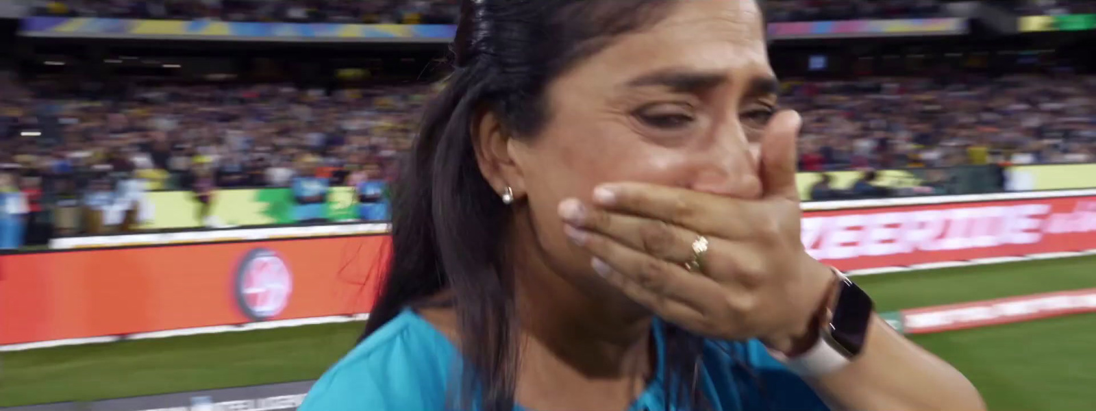 a woman covering her mouth in front of a crowd