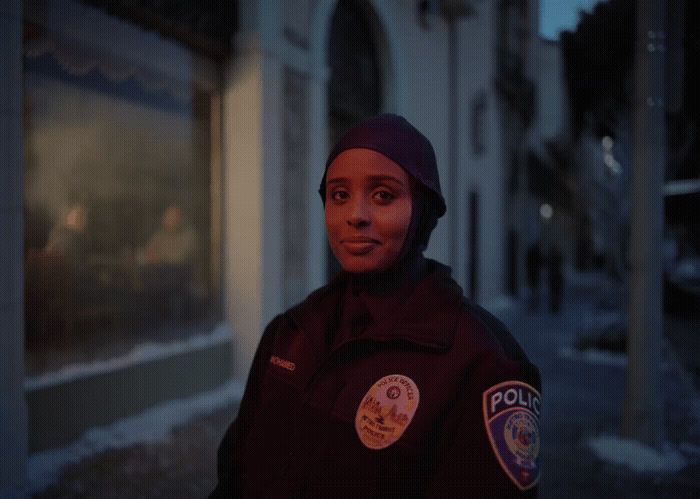 a woman police officer standing in front of a building