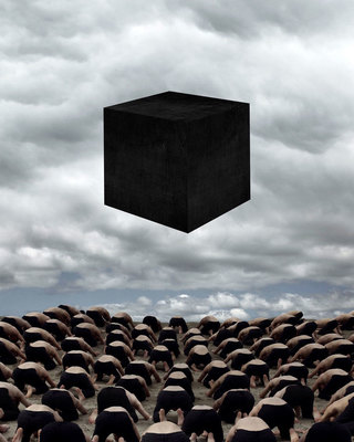 a large group of people standing in front of a black cube