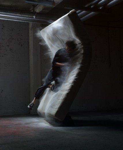 a man standing on top of a white object in a dark room