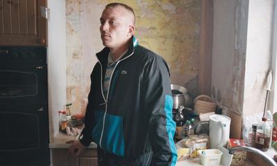 a man standing in a kitchen next to a stove