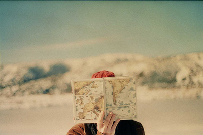 a woman holding a map in front of her face