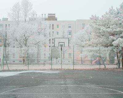 a basketball court surrounded by tall buildings and trees