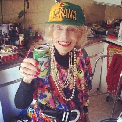 a woman wearing a hat holding a can of beer